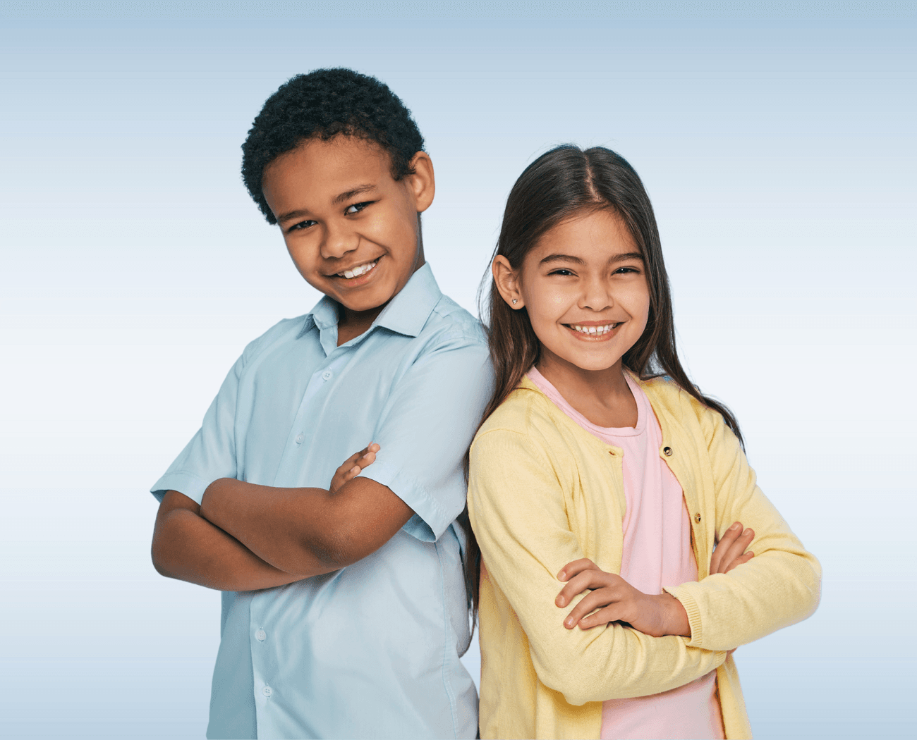 Two smiling children standing back to back with arms crossed